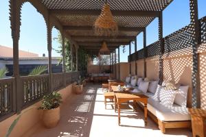 a patio with couches and tables on a deck at Riad Zaouia 44 in Marrakesh