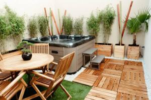 patio z wanną, stołem i krzesłami w obiekcie La Villetta SPA -logement atypique w Miluzie