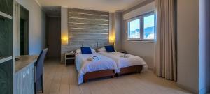 ein Hotelzimmer mit 2 Betten und einem Fenster in der Unterkunft Hotel Casa Marinella in Malcesine