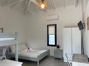 um quarto branco com um beliche e uma mesa em Simos Camping Elafonisos & Bungalows em Elafonisos