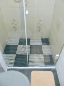 a bathroom with a shower with black and white tiles at Apartamento Charmoso com vista para o mar in Ilhabela +17 photos