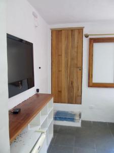 a living room with a flat screen tv on a wall at Apartamento Charmoso com vista para o mar in Ilhabela