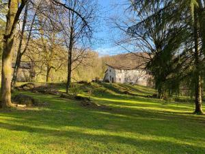 ein Haus auf einem Hügel mit Bäumen und einem grünen Feld in der Unterkunft LE TILLEUL DE BRESSOLLES in Brassac