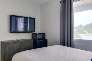 een slaapkamer met een bed en een tv aan de muur bij The ShoreHouse in Ocean City