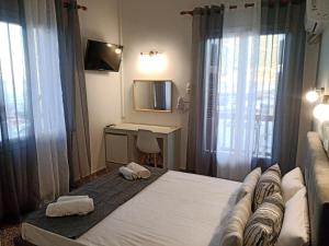 Schlafzimmer mit einem Bett, einem Schreibtisch und einem TV in der Unterkunft GEORGIOS L in Skopelos