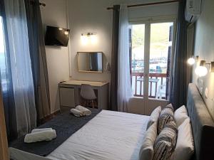 Schlafzimmer mit einem Bett, einem Fenster und einem Schreibtisch in der Unterkunft GEORGIOS L in Skopelos