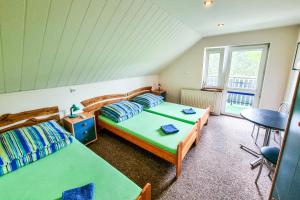 a bedroom with two beds and a table and chairs at Agroturystyka Alfa in Bystra