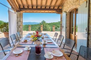 a long table on a patio with a view at Casale Dalmanuta in San Venanzo