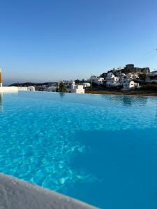 una piscina de agua azul y edificios de fondo en Acrothea Suites and Villas en Akrotiri