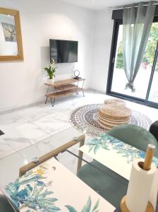Televízia a/alebo spoločenská miestnosť v ubytovaní L'escapade.T2 ☆ Jardin ☆ Spacieux ☆ Calme