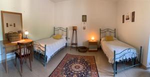 1 Schlafzimmer mit 2 Betten, einem Tisch und einem Schreibtisch in der Unterkunft Il Duca di Vietri in Vietri di Potenza