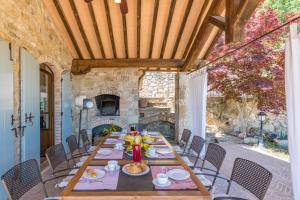 uma sala de jantar com uma mesa e uma lareira em Casale Dalmanuta em San Venanzo