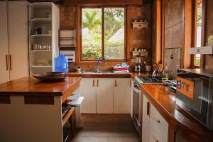 a kitchen with white cabinets and a sink and a window at Ayampe Guest House in Ayampe