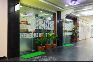 a lobby with potted plants in a building at Hotel Menaka in Vijayawāda