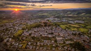 uma vista aérea de uma cidade ao pôr-do-sol em La Suite des Consuls em Sévérac d' Aveyron