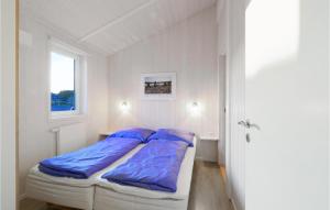 Bett in einem weißen Zimmer mit blauen Kissen in der Unterkunft St, Andreasberg, Haus 43 in Sankt Andreasberg