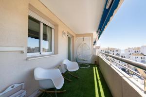 a balcony with two white chairs and a window at Apartment in Puerto Banus with pool views and parking in Marbella