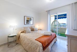 a bedroom with a bed and a large window at Apartment in Puerto Banus with pool views and parking in Marbella