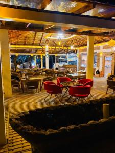 a restaurant with red chairs and tables and tables at Beach Queen Resort in Cox's Bazar