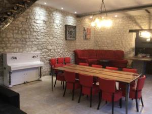 una sala da pranzo con tavolo e sedie rosse di Magnifique villa avec piscine chauffée et jacuzzi ad Anché