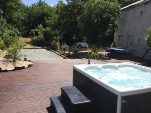 un jacuzzi sentado en la cubierta en Magnifique villa avec piscine chauffée et jacuzzi, en Anché