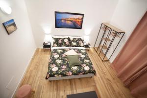 a bedroom with a bed with a floral bedspread at Il rifugio in Borgata in Syracuse