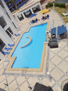 Jewel Sharm El Sheikh Hotel في شرم الشيخ: اطلالة علوية على مسبح مع كراسي ومظلات