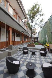 un patio con sillas y mesas en un suelo a cuadros en Hotel Loreto, en Santiago
