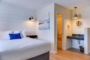 1 dormitorio con 1 cama y baño con lavamanos en The ShoreHouse en Ocean City