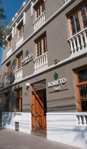 ein großes Gebäude mit einer Holztür davor in der Unterkunft Hotel Loreto in Santiago
