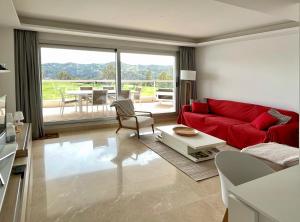 sala de estar con sofá rojo y mesa en Appartement du Bonheur, en La Cala de Mijas