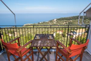 a table and chairs on a balcony with a view of the ocean at Elena Studios in Athani