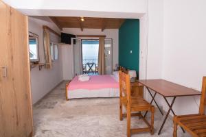 a bedroom with a bed and a desk and a table at Elena Studios in Athani