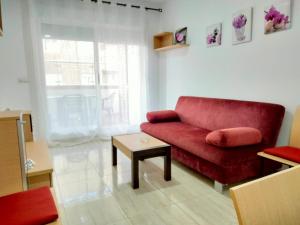 uma sala de estar com um sofá vermelho e uma mesa em ACV - Costa Marfil II - 2 linea planta 5 norte em Oropesa del Mar