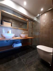 a bathroom with two sinks and a toilet and a shower at S.Nikolis' Historic Boutique Hotel in Rhodes Town