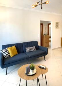 a blue couch in a living room with a table at URBAN APARTMENT in Lefkada Town