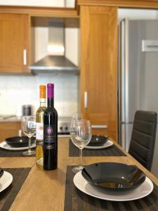 a table with two bottles of wine and glasses at URBAN APARTMENT in Lefkada Town