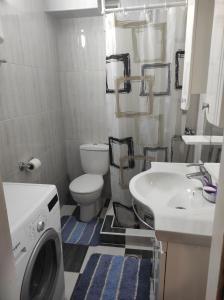 a bathroom with a washing machine and a sink at Emerald Suite in Valjevo