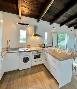 uma cozinha com um lavatório e uma máquina de lavar roupa em maison chaleureuse en plein coeur du centre ville em Saint-Florent
