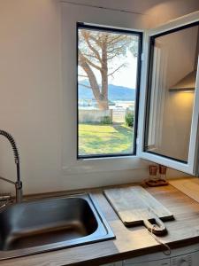 eine Küchentheke mit einem Waschbecken und einem Fenster in der Unterkunft maison chaleureuse en plein coeur du centre ville in Saint-Florent