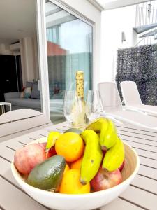 - un bol de fruits sur une table avec des verres à vin dans l'établissement Malibú Canteras Ático 22 con Terraza - Penthouse with Terrace, à Las Palmas de Gran Canaria
