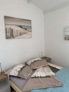 Bett in einem Zimmer mit einem Bild an der Wand in der Unterkunft Cap d'Agde Naturiste Hélio-village 95 in Cap d'Agde