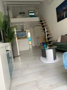 ein Wohnzimmer mit einer Wendeltreppe und einem Wohnzimmer in der Unterkunft Cap d'Agde Naturiste Hélio-village 95 in Cap d'Agde