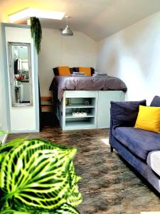 ein Schlafzimmer mit einem Bett, einem Sofa und einem Spiegel in der Unterkunft West Park Annex Central Wolverhampton in Wolverhampton