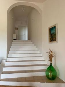 a stairway with a green vase sitting on a table at Casa Le Cicale in Porto Istana