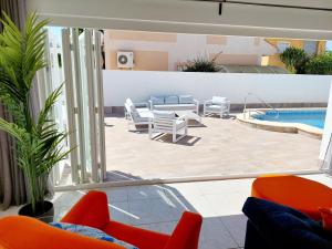 z widokiem na patio z krzesłami i basen w obiekcie Villa Palma - Heated Pool w mieście Los Alcázares