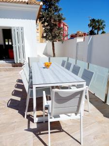 - biały stół i krzesła na patio w obiekcie Villa Palma - Heated Pool w mieście Los Alcázares
