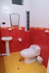 a red bathroom with a toilet and a sink at Flor del Valle in Tarapoto