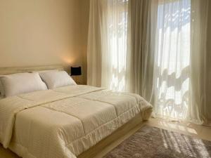 Un pat sau paturi într-o cameră la Lovely 1 Bedroom apt. At Mangroovy residence with free access to the Beach and Pools