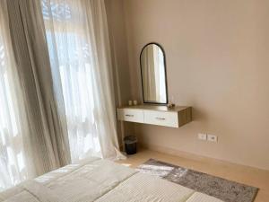 a bedroom with a bed and a mirror and a window at Lovely 1 Bedroom apt. At Mangroovy residence with free access to the Beach and Pools in Hurghada
